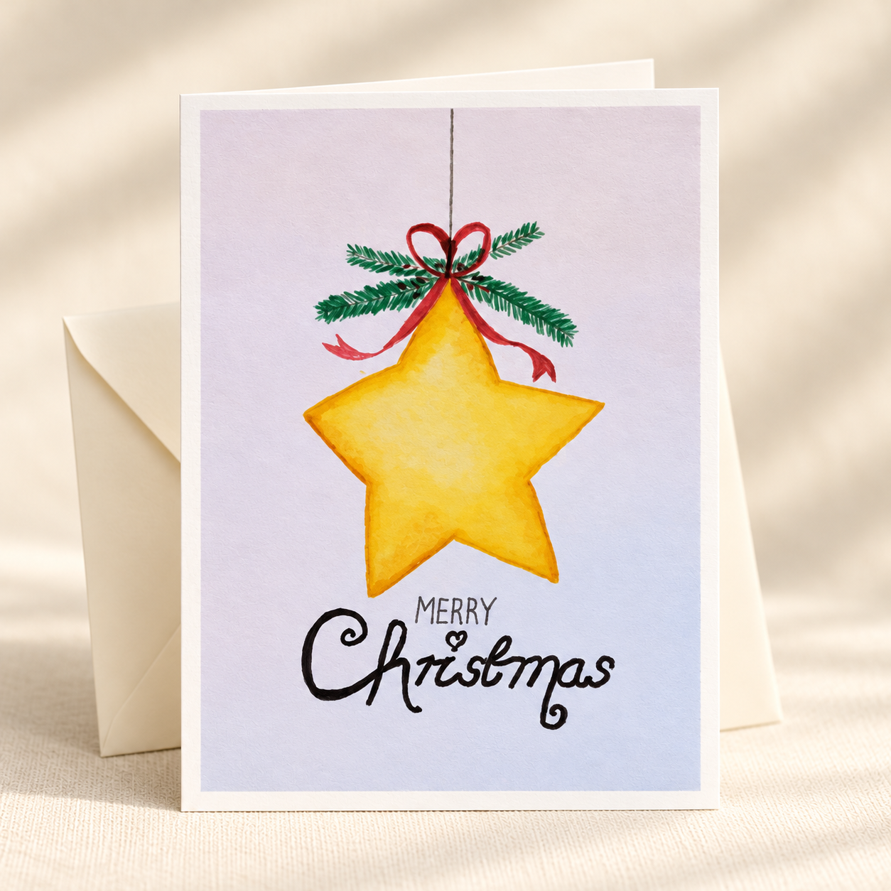 Christmas Star watercolor greeting card with an ivory envelope on a clean ivory background